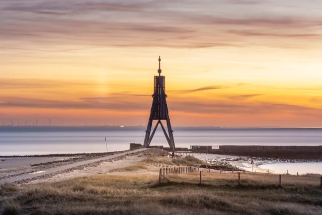 Die Kugelbake vor einem goldenen Himmel am Meer