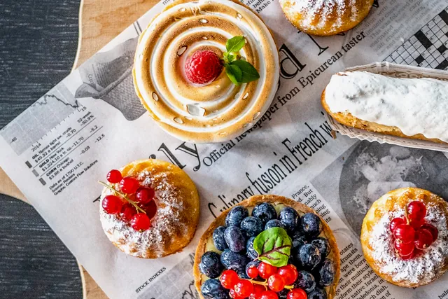 Tartelettes, Éclairs und kleine Kuchen mit frischen Beeren von oben fotografiert